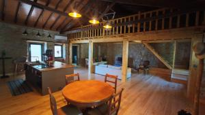 a kitchen and living room with a wooden table and chairs at Refúgio do Prado in Tomar