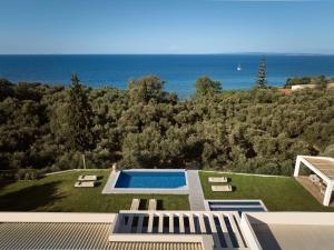 a house with a swimming pool and a view of the ocean at Cicada Exclusive Villa, a Sea View Gem, By ThinkVilla in Akrotiri