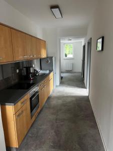 a kitchen with wooden cabinets and a hallway at Möbliertes Apartment in Arneburg