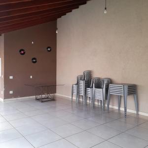 Un grupo de sillas alineadas contra una pared en Área de lazer em Brodowski, en Brodósqui