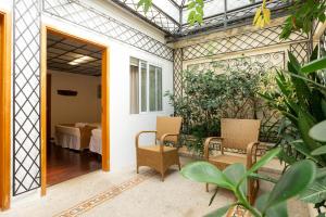 an open door to a patio with chairs and a table at Vilarejo - Centro Histórico Ilhabela in Ilhabela