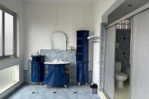 a bathroom with blue cabinets and a sink and a toilet at Hotel Pesona Bamboe Lembang in Genteng +105 photos