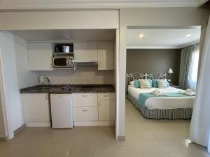 a kitchen and a bedroom with a bed in a room at RF La Quinta Park Suites in Santa Úrsula