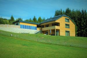 una grande casa in cima a una collina erbosa di Chalet Traumblick a Mauterndorf