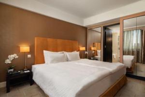 a bedroom with a large white bed in a hotel room at Verdi Budapest Aquincum in Budapest
