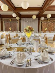 a large dining room with white tables and chairs at Verdi Budapest Aquincum in Budapest