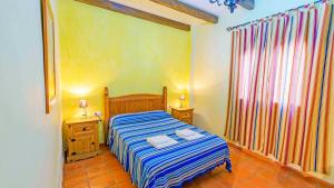 a bedroom with a bed with two night stands and two lamps at La Chumbera Órgiva by Ruralidays in Órgiva +7 photos