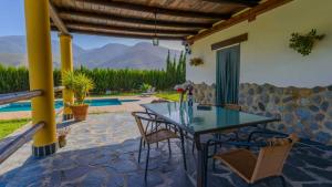 a table and chairs on a patio with a view at La Chumbera Órgiva by Ruralidays in Órgiva