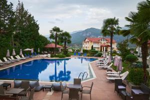a pool at a resort with chairs and tables at Famissi Suites in Kalabaka