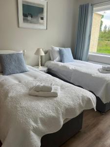 dwa łóżka ustawione obok siebie w sypialni w obiekcie Blessingbourne Cottages & Apartments w mieście Fivemiletown +130 zdjęć