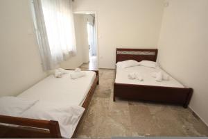 two beds in a small room with a window at Nikolas Marios by Frangki in Agia Marina Aegina