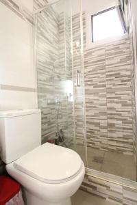 a bathroom with a toilet and a glass shower at Nikolas Marios by Frangki in Agia Marina Aegina +8 photos