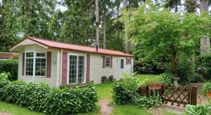 a small house with a red roof in a yard at Woudthuisje in Laag-Soeren