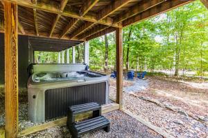 an outdoor grill sitting inside of a screened in porch at Modern w Fire Pit Deck, Grill & Hot Tub in Berkeley Springs