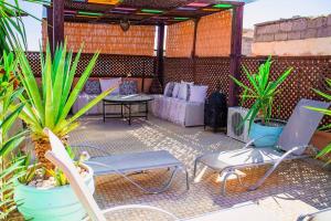 a patio with a table and chairs and plants at Riad - In Medina - Kesh Design in Marrakesh