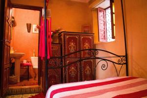 a bedroom with a bed and a bathroom with a mirror at Riad - In Medina - Kesh Design in Marrakesh +12 photos