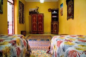 two beds in a room with yellow walls at Riad - In Medina - Kesh Design in Marrakesh