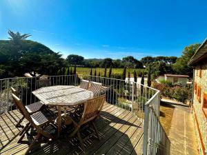 a table and chairs on a deck with a fence at Les figuiers in La Londe-les-Maures
