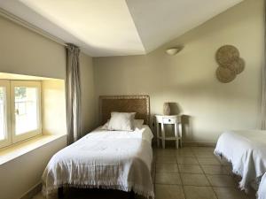 a bedroom with two beds and a window at Les figuiers in La Londe-les-Maures