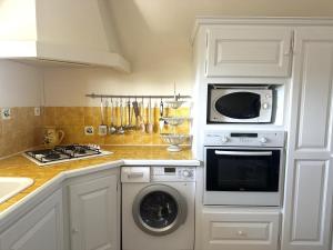 a kitchen with a washing machine and a microwave at Les figuiers in La Londe-les-Maures