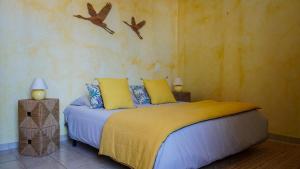 a bedroom with a bed and two birds on the wall at Les tamaris in La Londe-les-Maures +2 photos