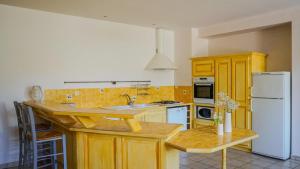 a kitchen with wooden cabinets and a white refrigerator at Les tamaris in La Londe-les-Maures