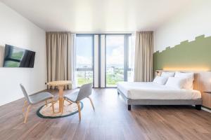 日内瓦B&B HOTEL Geneva Airport的一间带床、桌椅的酒店房间