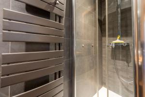 a shower in a bathroom with a shower head at Appartements Bétemps in Le Grand-Bornand +12 photos