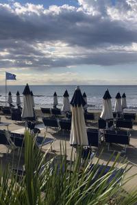 a group of chairs and umbrellas on a beach at Villa Marina in Marina dʼAndora +47 photos