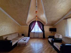 a living room with couches and a large window at Jermuk Villa Imperial in Jermuk