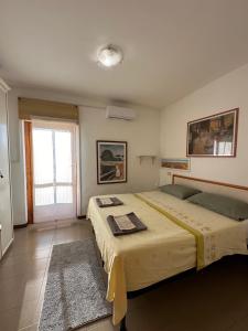 a bedroom with two beds and a window at Un posto al sole in Fregene +9 photos