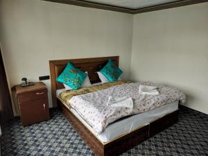 a bedroom with a bed with blue pillows at Ibex spangri cottage in Lukung