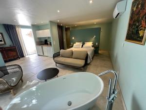a bathroom with a bath tub and a bedroom at Le Clos Saint André in Banyuls-sur-Mer