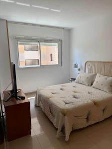 a white bedroom with a bed and a window at Lindo piso residencial en salou centrico in Salou