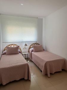 two beds sitting next to each other in a room at Lindo piso residencial en salou centrico in Salou