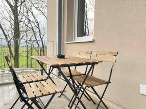 a wooden table and two chairs next to a window at AM1036 - Moderne Monteurwohnung mit Balkon in Amberg