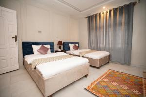 a bedroom with two beds and a door with a window at Green orchard skardu in Skardu
