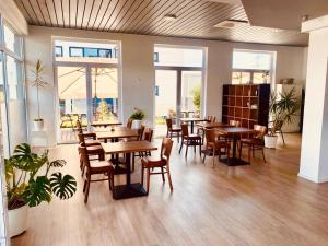 a restaurant with wooden tables and chairs and windows at Hotel Rodgau in Rodgau