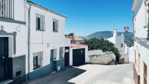 an alley with white buildings and a gate at Casa del Patito with Vista by Duckling Stays in Olvera