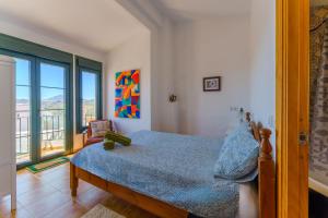 a bedroom with a bed and a large window at Casa del Patito with Vista by Duckling Stays in Olvera