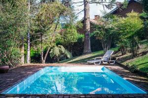 a swimming pool in the yard of a house at Pousada da Trilha in Monte Verde