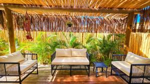 a porch with two chairs and a white couch at Villa Mediterrâneo Trancoso in Trancoso +109 photos