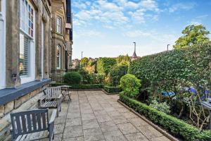 a patio with two benches on a house at Garden Mews - 2 double bedrooms - Harrogate Holiday Apartments in Harrogate