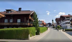 a street in a town with houses and a person riding a bike at Appartement Wurzrainer in Westendorf +54 photos