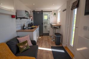 a small living room with a couch and a kitchen at Hut on the Hill in Aird of Sleat
