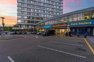 a large building with cars parked in a parking lot at Heathrow Retail Park Apartment Sleeps SEVEN Turbo WiFi in Sunbury Common