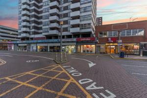 an empty street in front of a building at Heathrow Retail Park Apartment Sleeps SEVEN Turbo WiFi in Sunbury Common