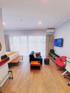 eine Person, die auf einer Couch in einem Wohnzimmer sitzt in der Unterkunft BRAND NEW! Modern amazing 1Bed - Princes Wharf in Auckland