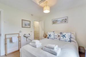 ein Schlafzimmer mit einem weißen Bett mit Handtüchern darauf in der Unterkunft Fisherman's Cottage in Hastings Old Town in Hastings