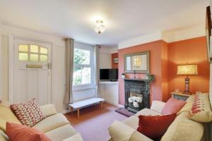 ein Wohnzimmer mit zwei Sofas und einem Kamin in der Unterkunft Fisherman's Cottage in Hastings Old Town in Hastings